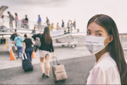 Woman wearing a mask boarding a plane